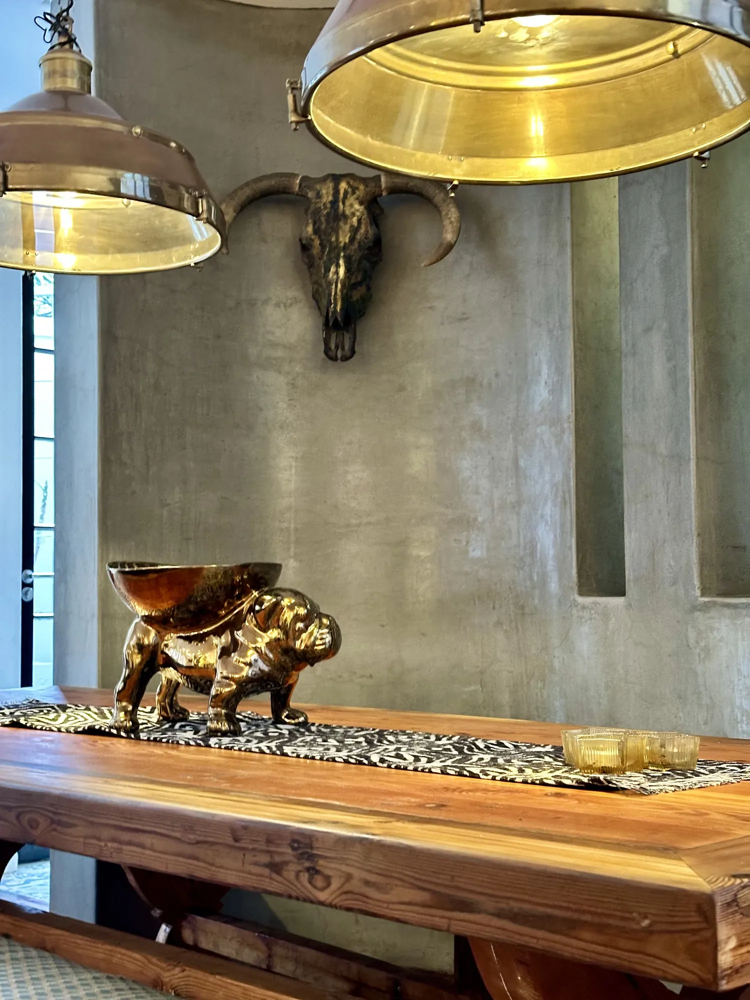 Brass pendant lights over the timber dining table at Casa Dias