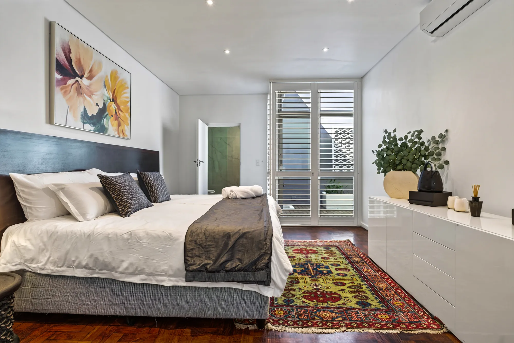 A Casa Dias bedroom with floral artwork and courtyard shutters